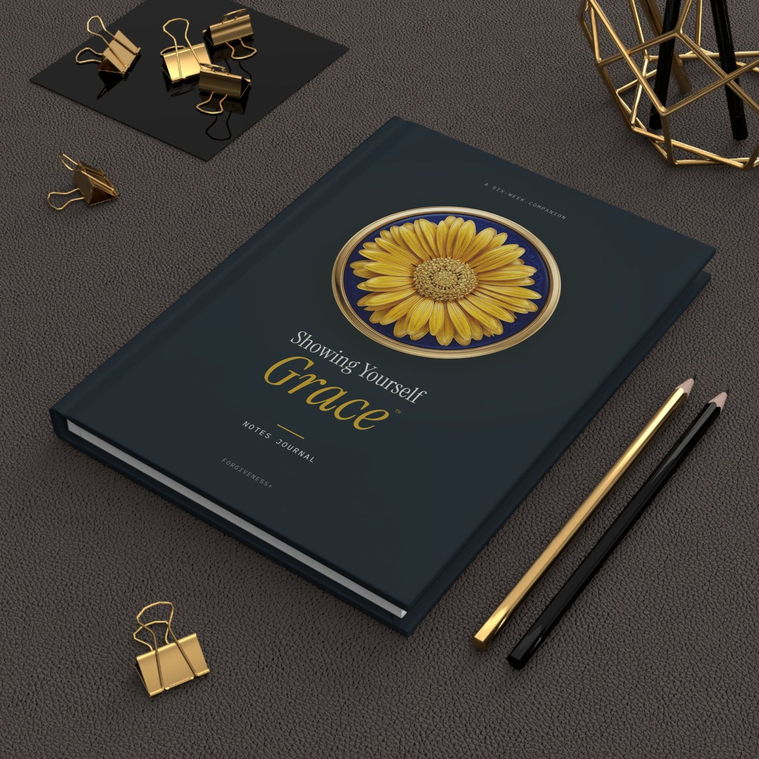 The Showing Yourself Grace Notes Journal on a desk beside gold pencils